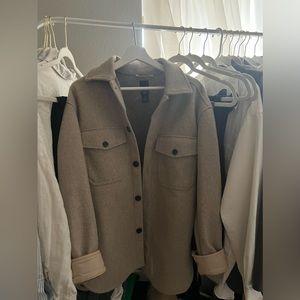 Tan mid length shacket/shirt jacket.